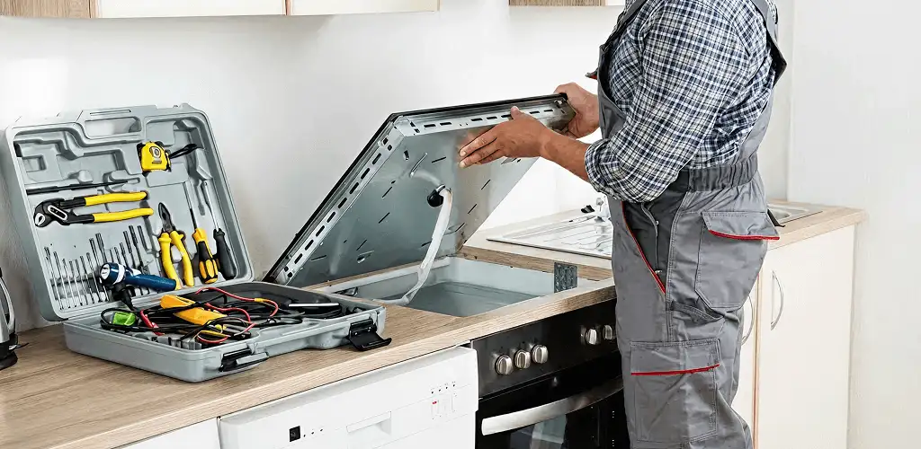 Handyman repairing a cooktop and checking wiring connections in Albuquerque, NM