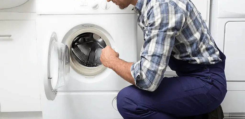 Handyman inspecting a dryer drum and internal parts for repair in Albuquerque, NM