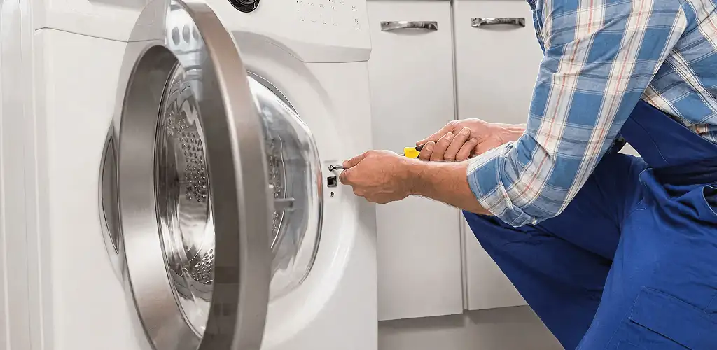 Handyman repairing a clothes dryer and checking electrical connections in Albuquerque, NM