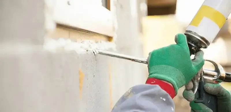 Handyman sealing exterior gaps with caulk for weatherproofing in Albuquerque, NM