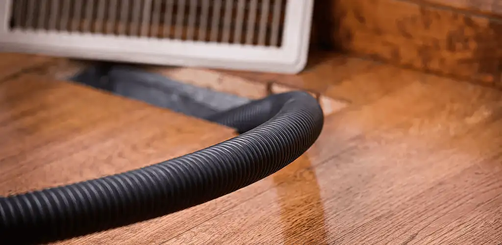 Air duct cleaning hose inserted into a floor vent for ductwork cleaning in Albuquerque, NM