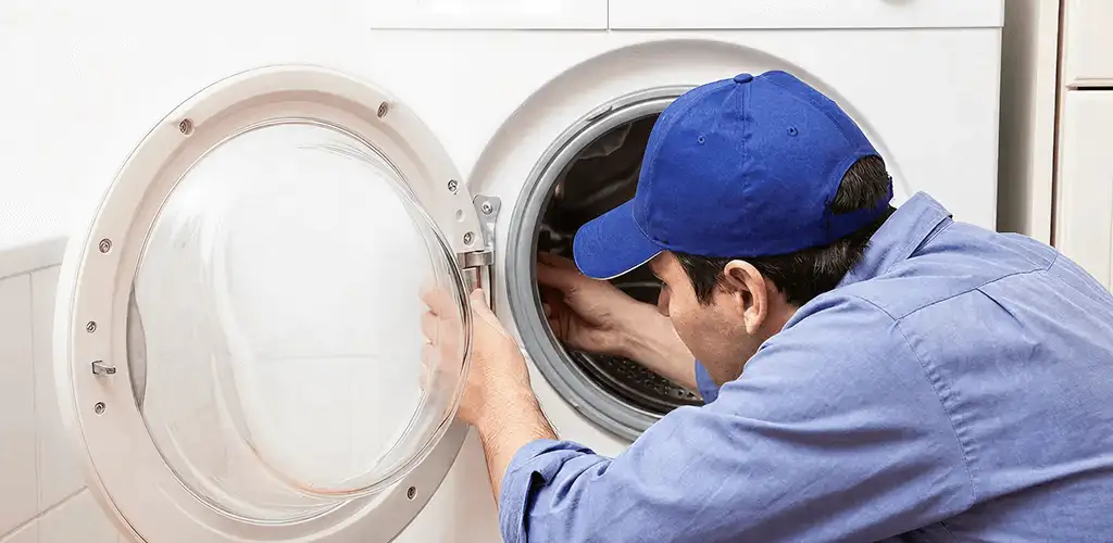 Washing machine repair handyman inspecting a front-load washer drum in Albuquerque, NM