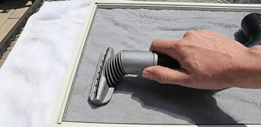 Window screen repair cleaning and fixing a damaged screen mesh in Albuquerque, NM